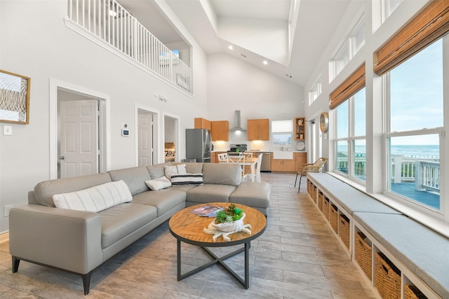 living room featuring light wood-style flooring, recessed lighting, and a towering ceiling