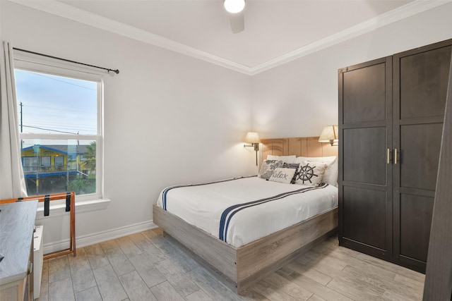 bedroom with a ceiling fan, light wood-style flooring, ornamental molding, and baseboards