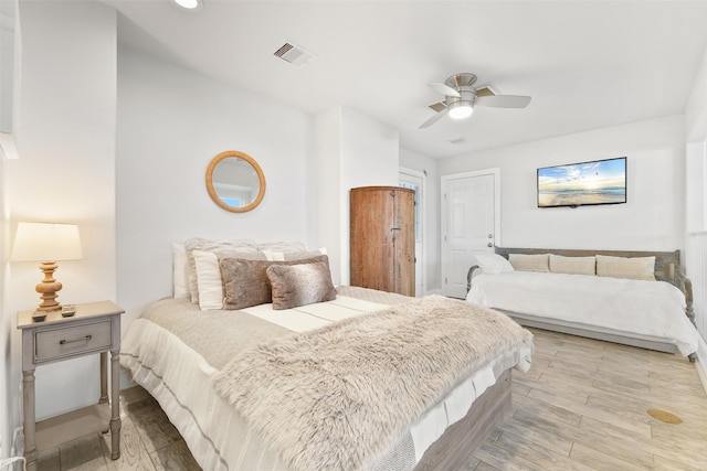 bedroom featuring light wood-type flooring, visible vents, and a ceiling fan