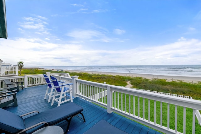 deck featuring a lawn, a water view, and a view of the beach