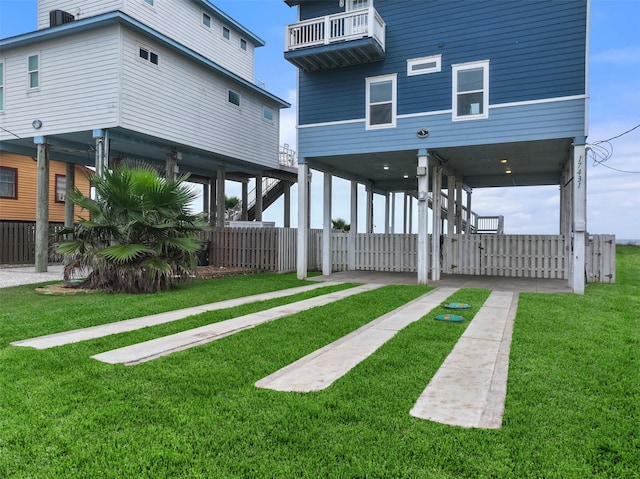 view of yard with fence and a balcony