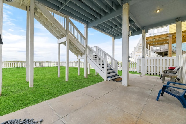 view of patio featuring stairs and fence