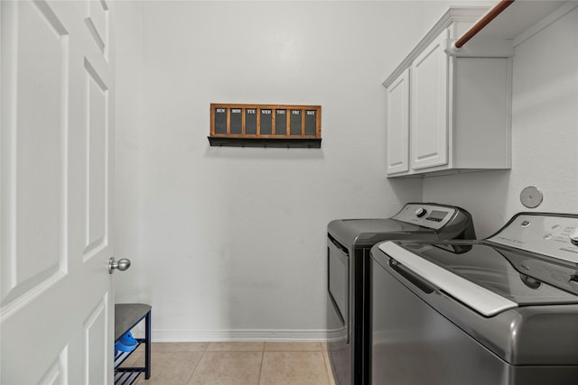 clothes washing area featuring light tile patterned floors, cabinets, and separate washer and dryer