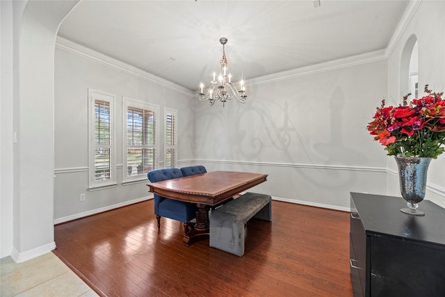 dining room with hardwood / wood-style flooring, a notable chandelier, and ornamental molding