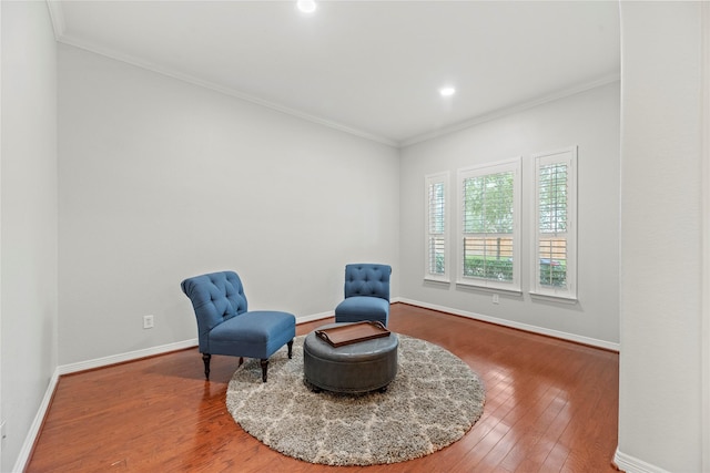 sitting room with ornamental molding and hardwood / wood-style floors