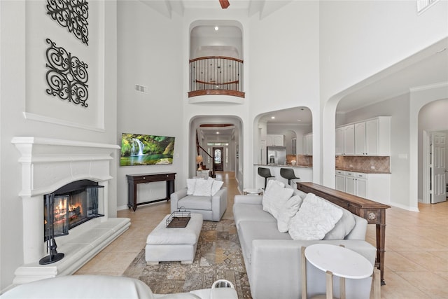 living room with a high ceiling, beam ceiling, and light tile patterned floors