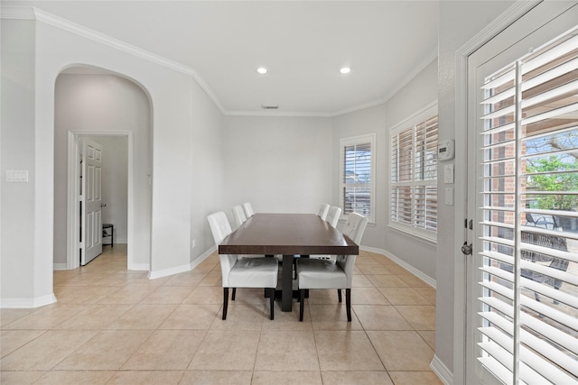 tiled dining space with plenty of natural light and crown molding