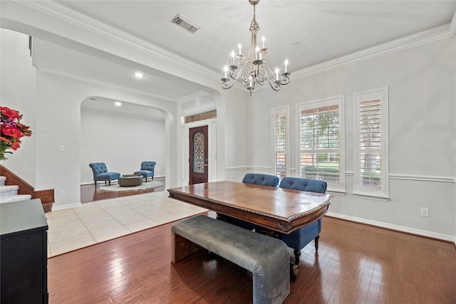 dining space featuring hardwood / wood-style flooring, a chandelier, and crown molding