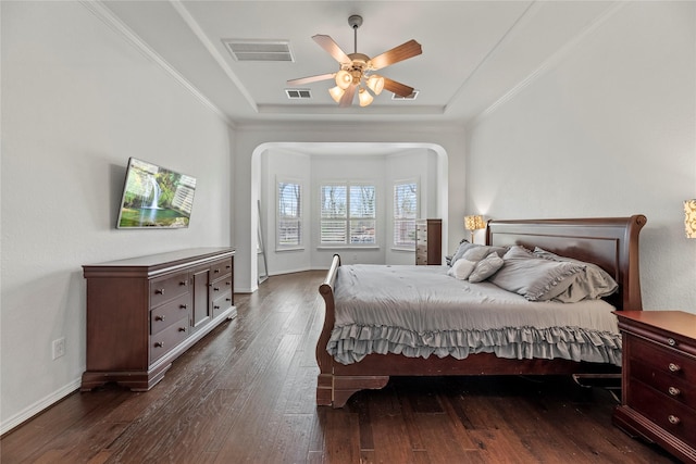 bedroom featuring ceiling fan, crown molding, dark hardwood / wood-style floors, and a raised ceiling