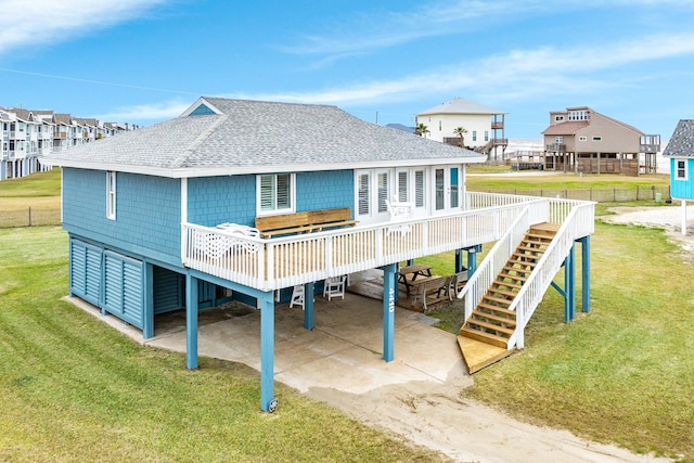 back of house featuring a carport, a deck, and a lawn