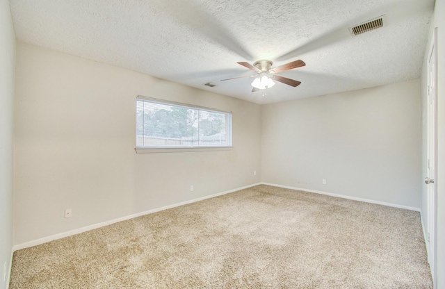 carpeted empty room featuring ceiling fan and a textured ceiling