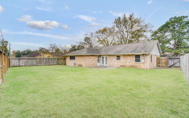 rear view of property featuring french doors and a lawn