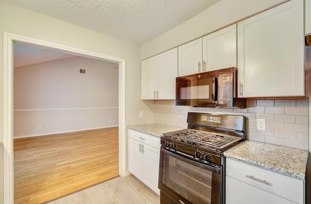 kitchen with black appliances, light hardwood / wood-style floors, white cabinets, a textured ceiling, and decorative backsplash