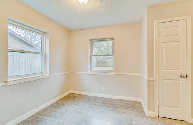 unfurnished room featuring plenty of natural light and a textured ceiling