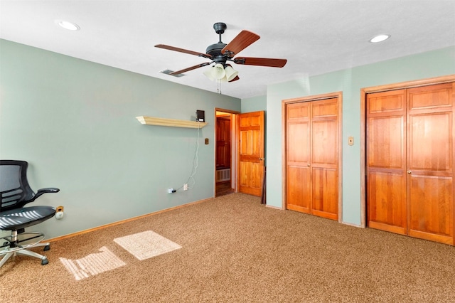 unfurnished bedroom with two closets, ceiling fan, and carpet flooring