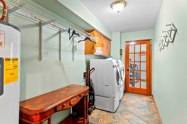 washroom featuring water heater, washing machine and clothes dryer, and cabinets