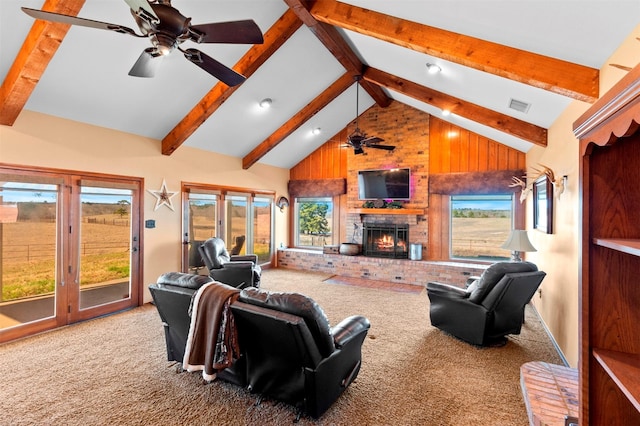 carpeted living room with beamed ceiling, high vaulted ceiling, a brick fireplace, and a wealth of natural light