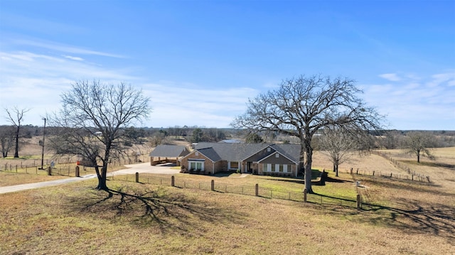 ranch-style home featuring a rural view and a front lawn