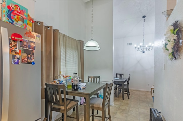 dining area with a chandelier and a towering ceiling