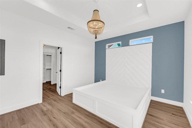 interior space featuring a chandelier, hardwood / wood-style floors, and a raised ceiling