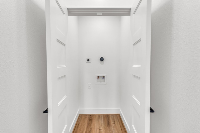 clothes washing area featuring hookup for a washing machine, hardwood / wood-style flooring, and hookup for an electric dryer