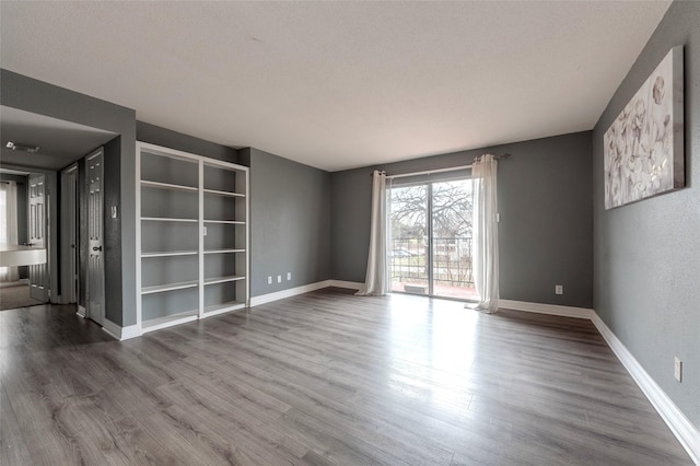 empty room featuring hardwood / wood-style flooring and a textured ceiling