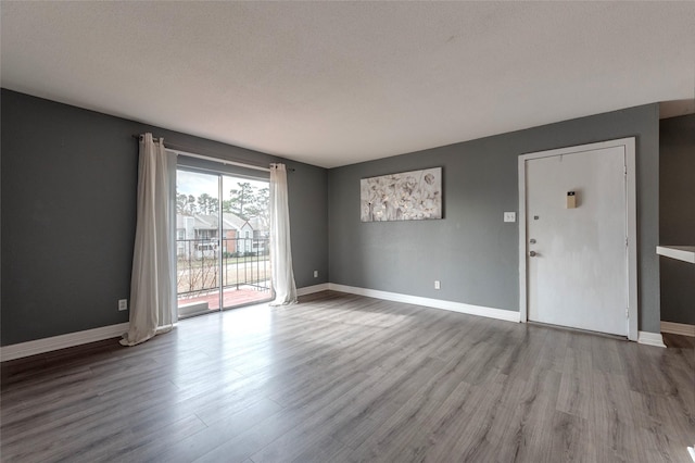 empty room with light hardwood / wood-style floors and a textured ceiling