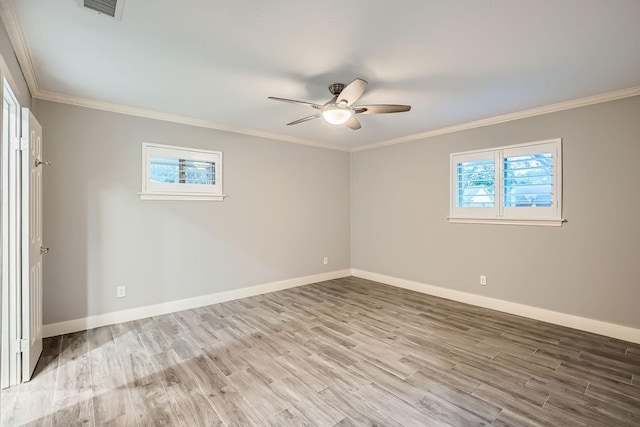 empty room featuring crown molding, ceiling fan, a healthy amount of sunlight, and wood-type flooring