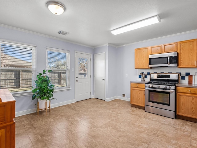 kitchen featuring ornamental molding, appliances with stainless steel finishes, and decorative backsplash