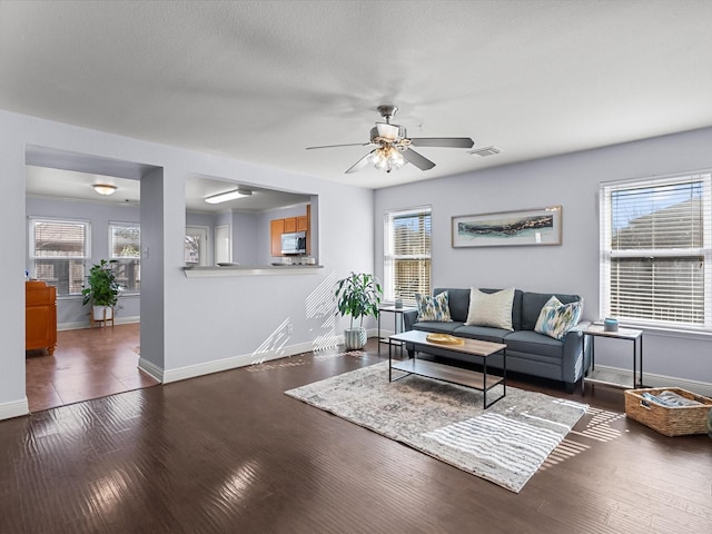 living room with ceiling fan and dark hardwood / wood-style floors