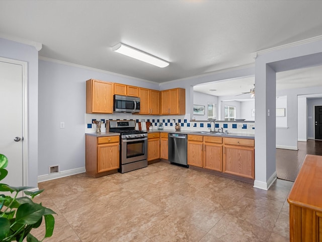 kitchen with sink, crown molding, ceiling fan, appliances with stainless steel finishes, and tasteful backsplash