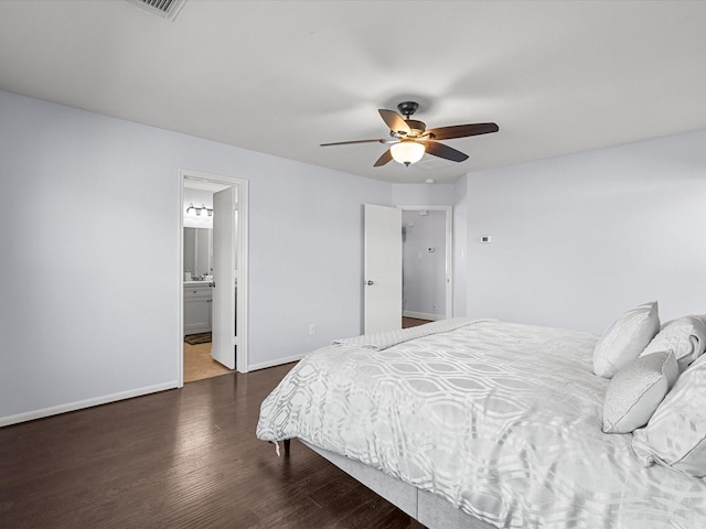 bedroom with ensuite bath, dark wood-type flooring, and ceiling fan