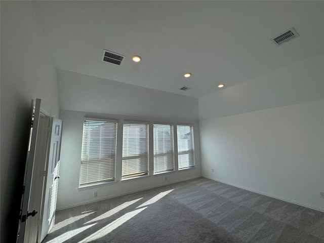 unfurnished room with dark colored carpet and lofted ceiling