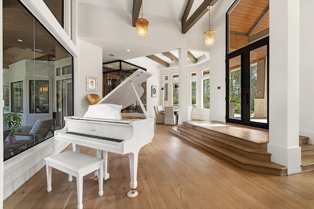 misc room with beam ceiling, light hardwood / wood-style floors, and high vaulted ceiling