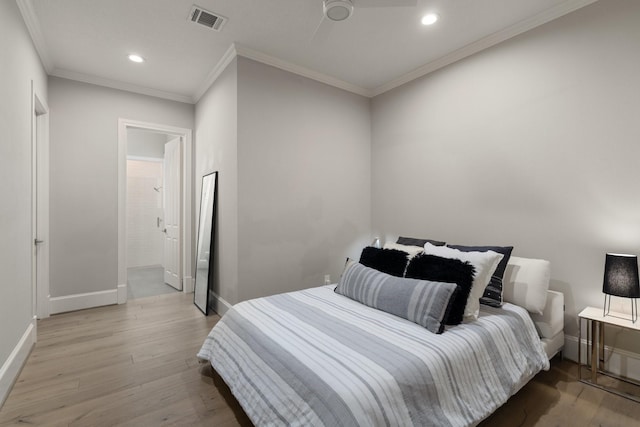 bedroom featuring ceiling fan, crown molding, connected bathroom, and light hardwood / wood-style floors