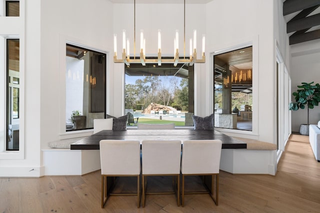 dining area with breakfast area, a chandelier, and light wood-type flooring