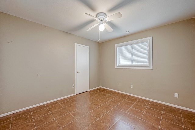 tiled empty room featuring ceiling fan