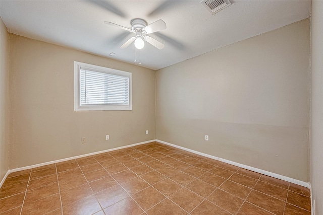 spare room featuring tile patterned floors and ceiling fan