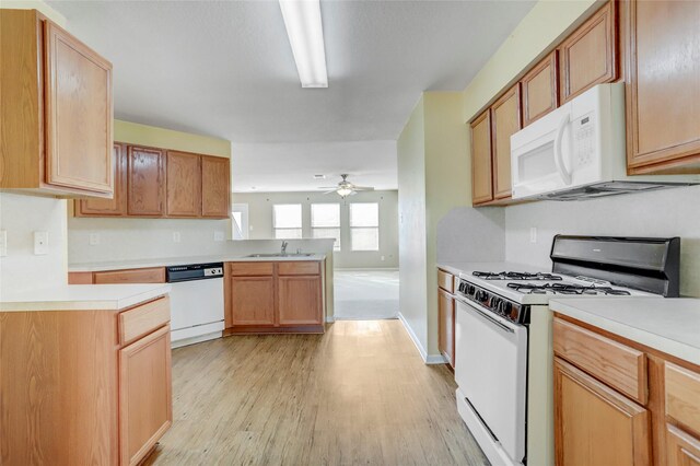 kitchen with ceiling fan, sink, white appliances, and light wood-type flooring