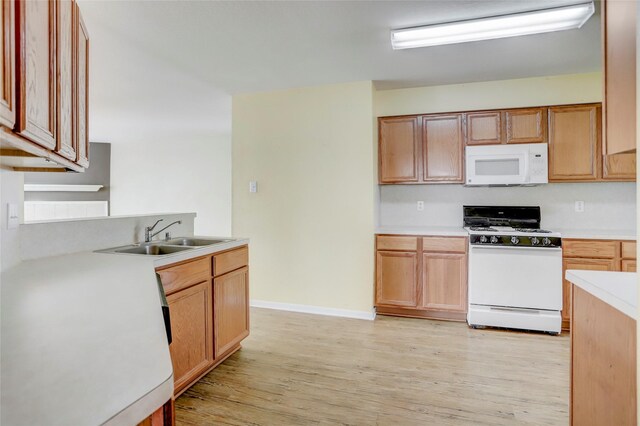 kitchen with light hardwood / wood-style floors, sink, and white appliances