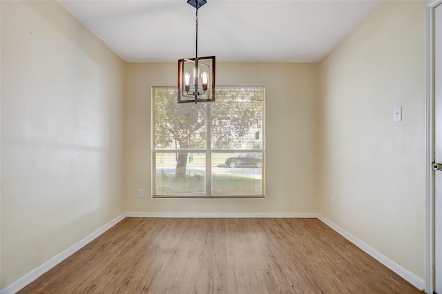 unfurnished dining area featuring hardwood / wood-style floors and a chandelier