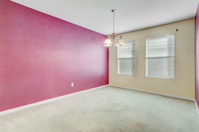 unfurnished room with an inviting chandelier and carpet