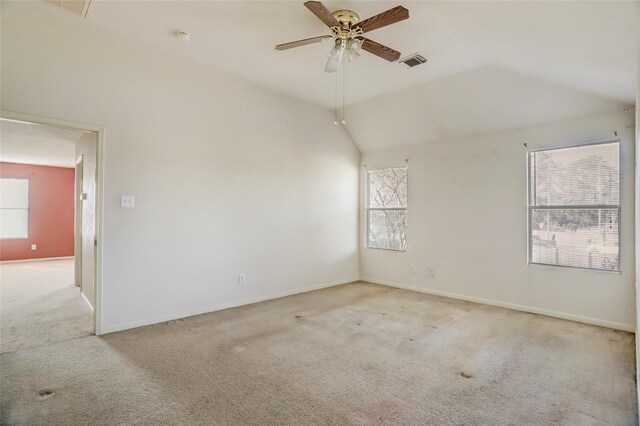 carpeted spare room featuring vaulted ceiling, a wealth of natural light, and ceiling fan