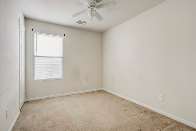 carpeted spare room featuring ceiling fan