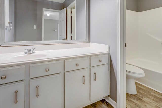 full bathroom featuring vanity, toilet, shower / washtub combination, and wood-type flooring