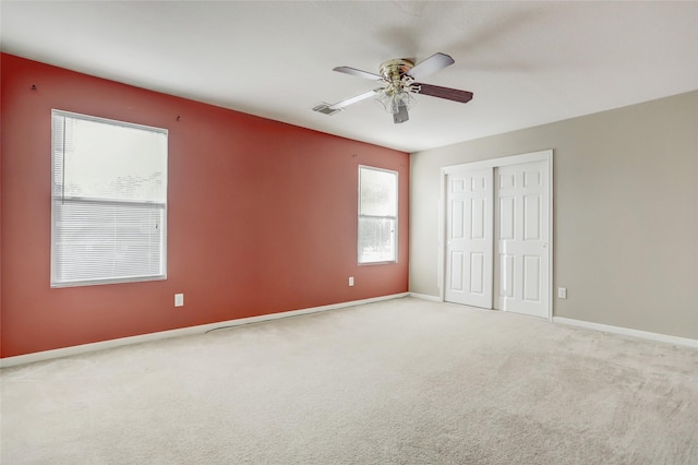 unfurnished bedroom with carpet, a closet, and ceiling fan