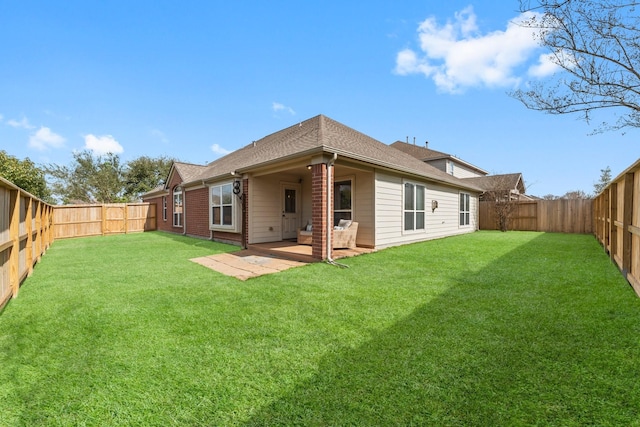 rear view of house featuring a yard and a patio area