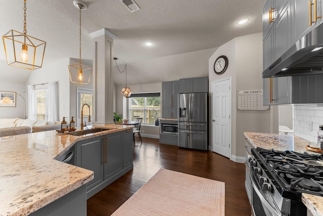 kitchen with gray cabinets, sink, hanging light fixtures, light stone counters, and stainless steel appliances