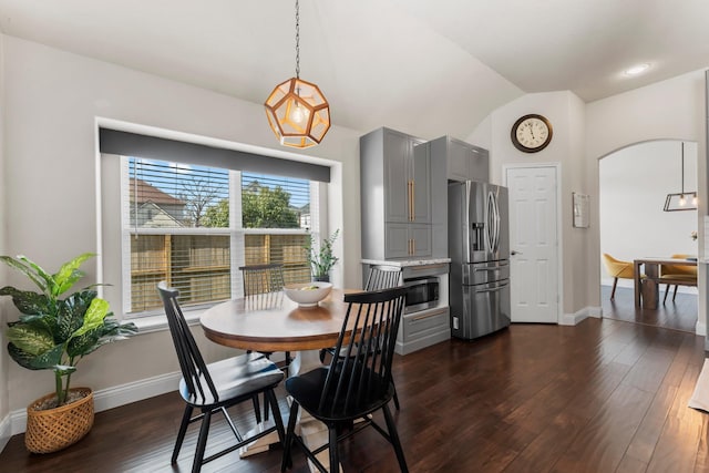 dining space with lofted ceiling and dark wood-type flooring