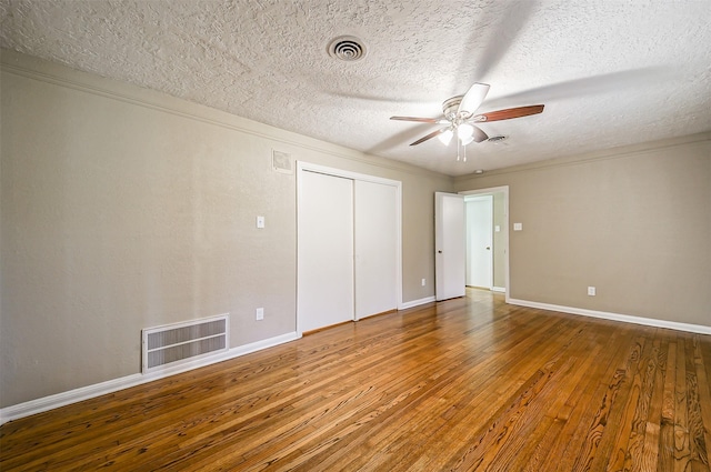 unfurnished bedroom featuring ceiling fan, a textured ceiling, hardwood / wood-style flooring, and crown molding